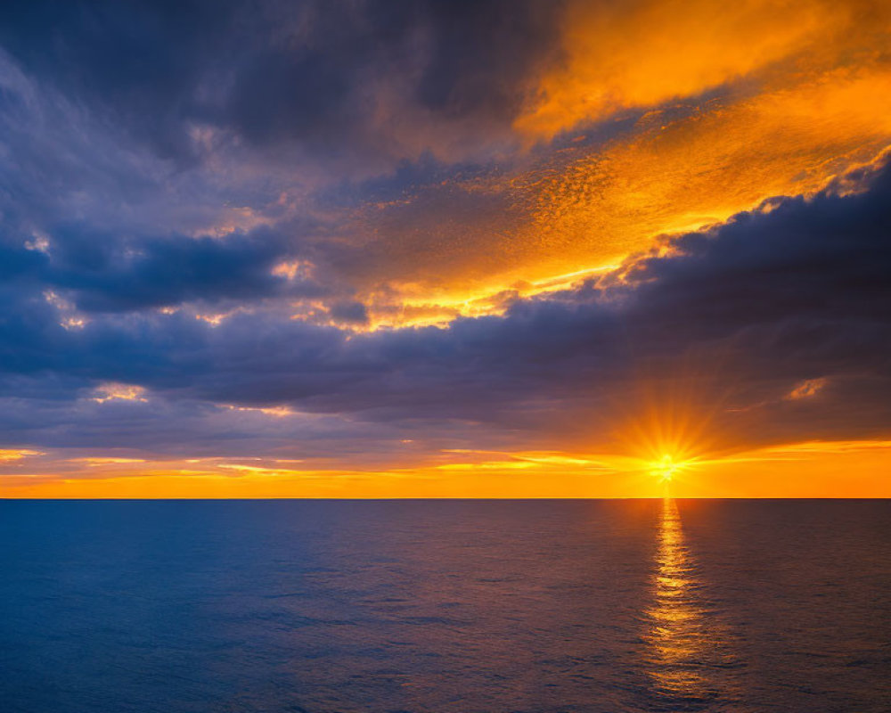 Vibrant ocean sunset with golden glow on clouds and sea