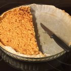 Freshly Baked Pear Pie with Lattice Crust and Knife on Wooden Surface