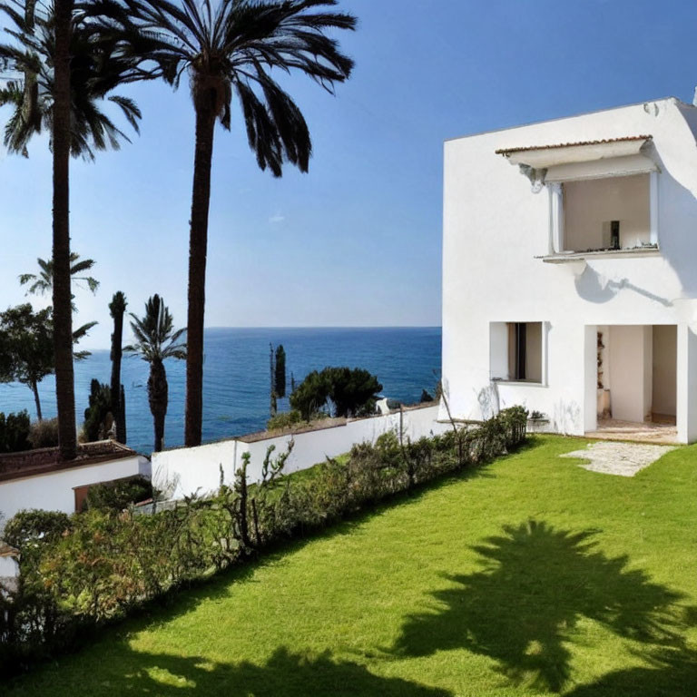 White Villa with Sea View, Lush Lawn, Palm Trees, and Clear Sky