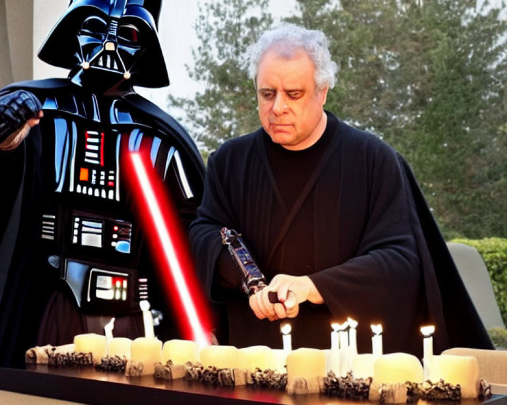 Person in Darth Vader costume with lightsaber beside man lighting candles