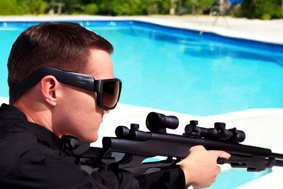 Man with Sunglasses and Headset Aiming Rifle by Swimming Pool