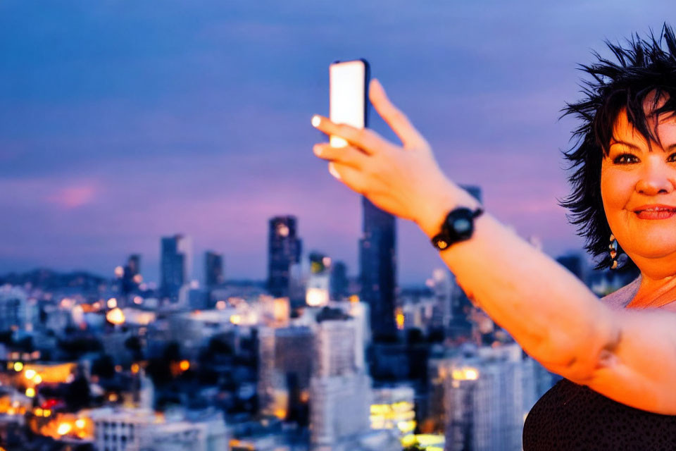 Person taking selfie against city skyline at sunset with urban backdrop.