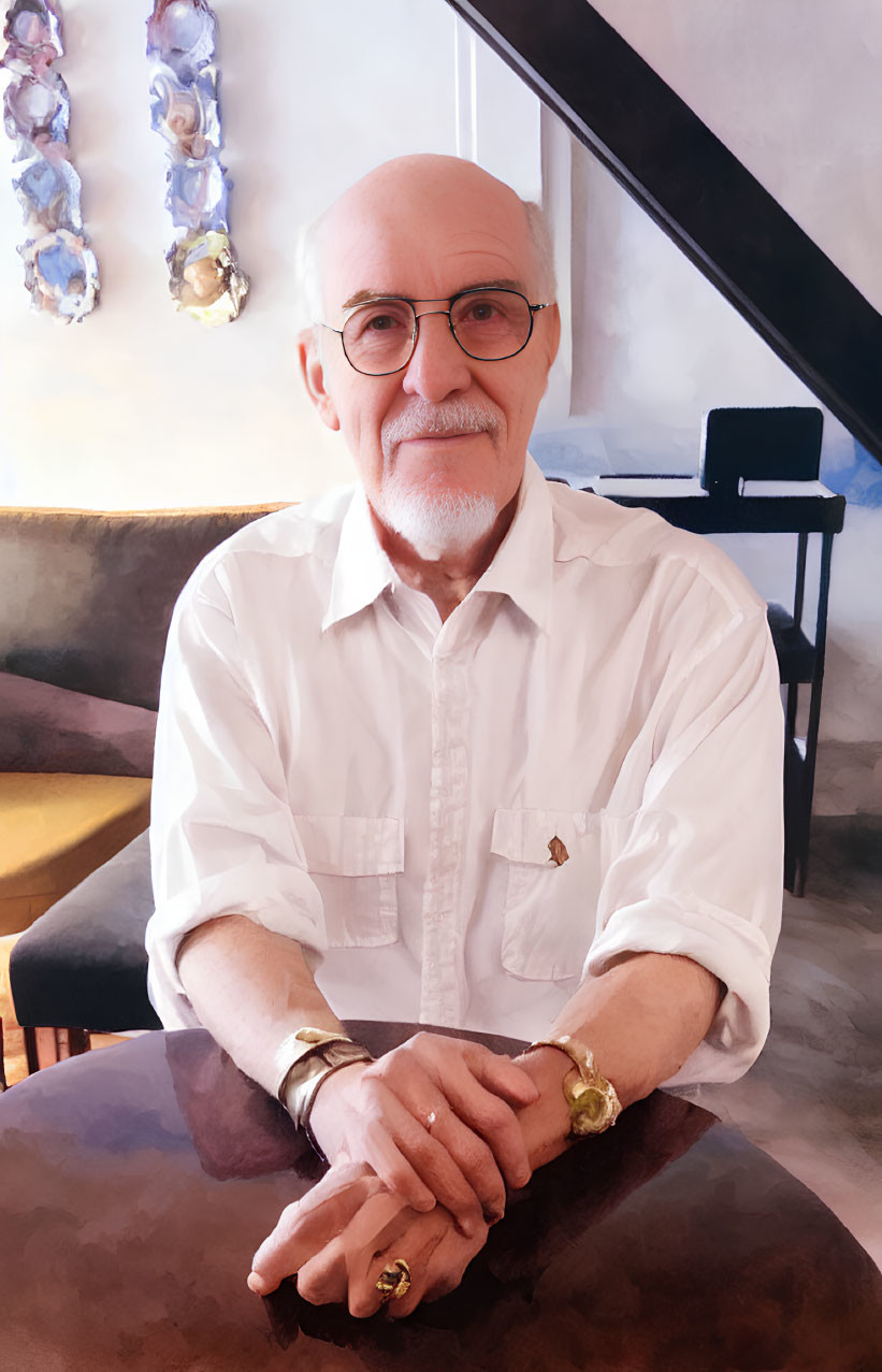 Elderly man with white beard and glasses sitting at table