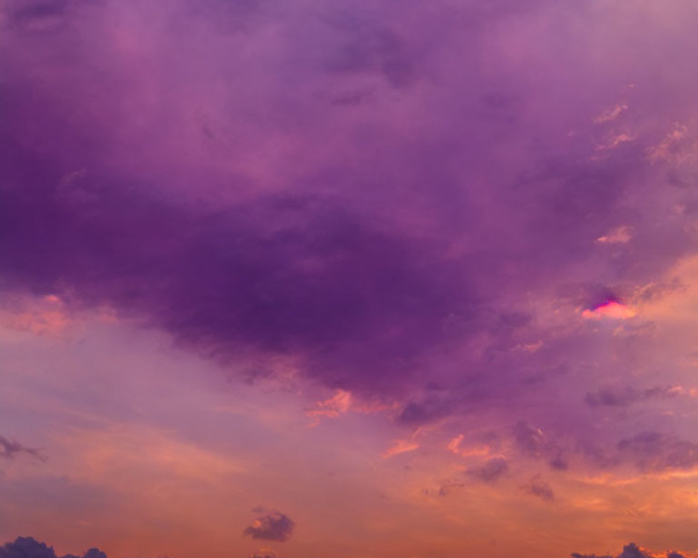 Colorful purple and golden sunset over cloud-streaked sky