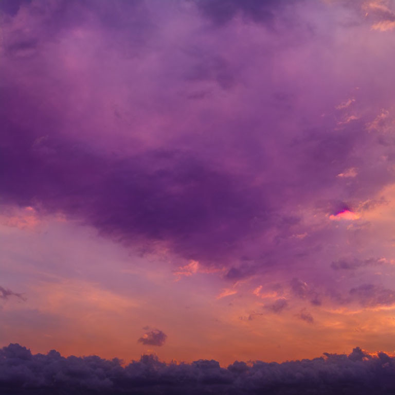 Colorful purple and golden sunset over cloud-streaked sky