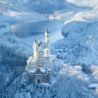 Snow-covered castle with spires and towers in icy landscape