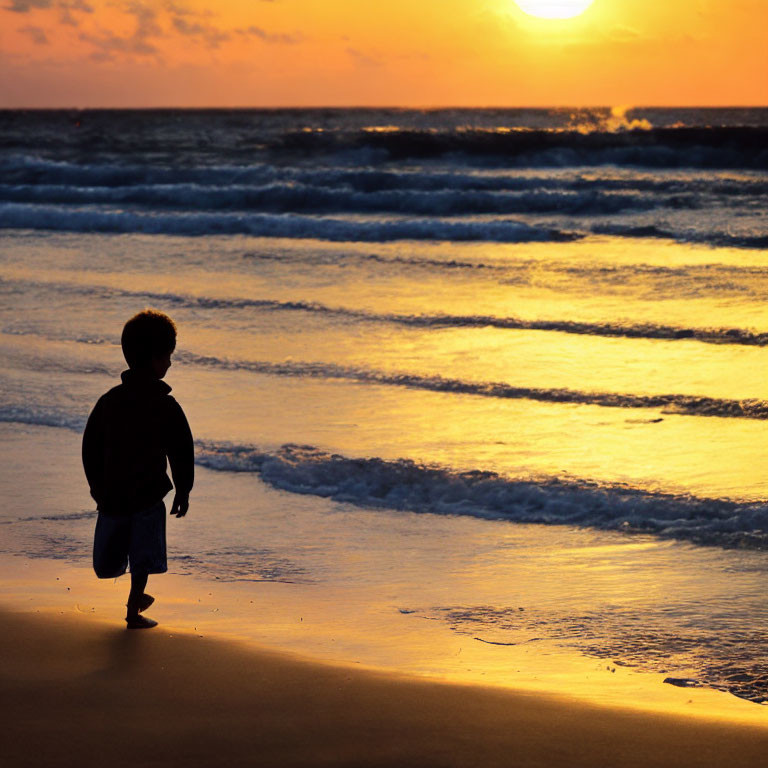 Child Silhouetted on Sandy Beach at Sunset