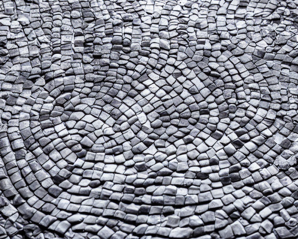 Detailed close-up of circular cobblestone pavement texture in varying shades of gray