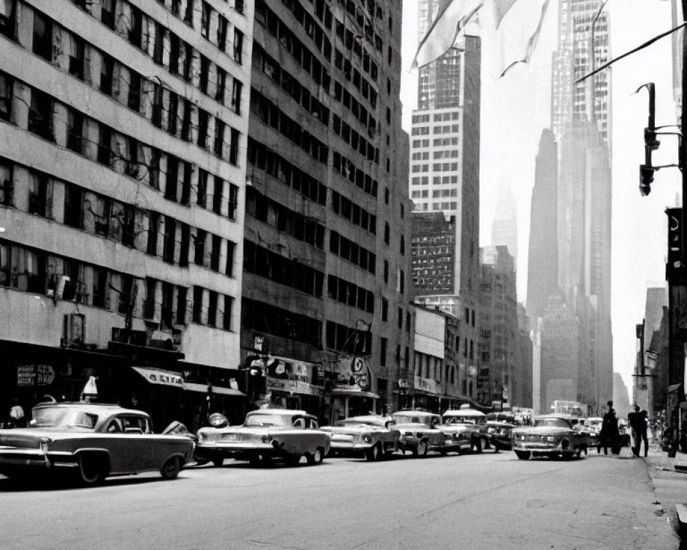 Vintage black and white photo of old city street with vintage cars and towering buildings