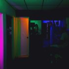 Neon-lit corridor with futuristic doors and glowing signs