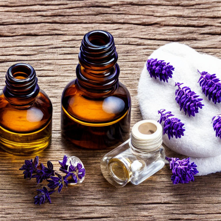 Amber Glass Bottles with Essential Oils and Lavender Sprigs on Wooden Surface