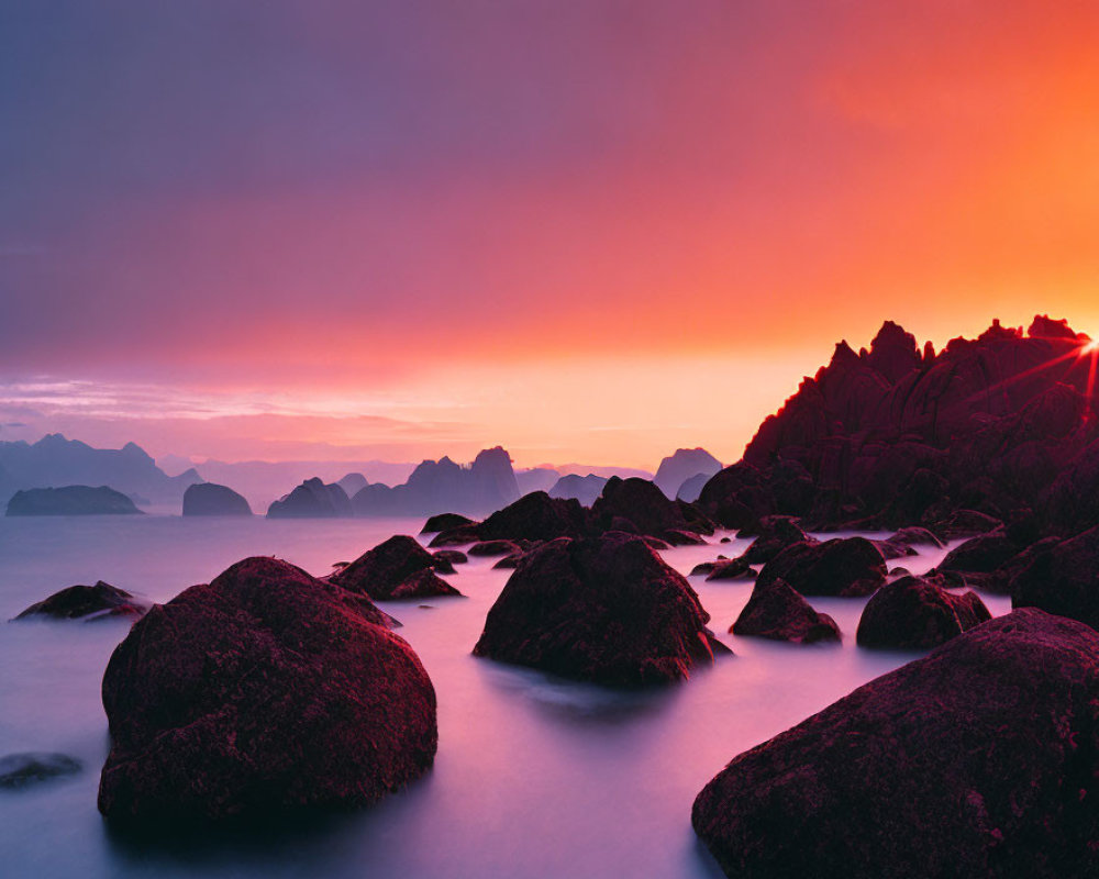 Serene sea sunset with pink and orange hues, silhouettes of rocks, sun on horizon