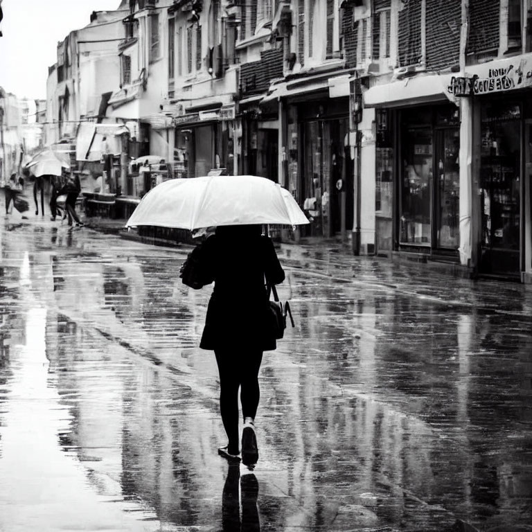 Pedestrian with umbrella walking on wet street under rain, reflecting buildings.