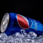 Vibrant blue and red hair individuals in blue outfits lying on the ground with overturned silver prop