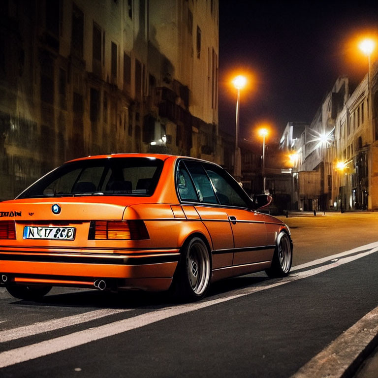 Orange BMW Car Parked on Urban Street at Night