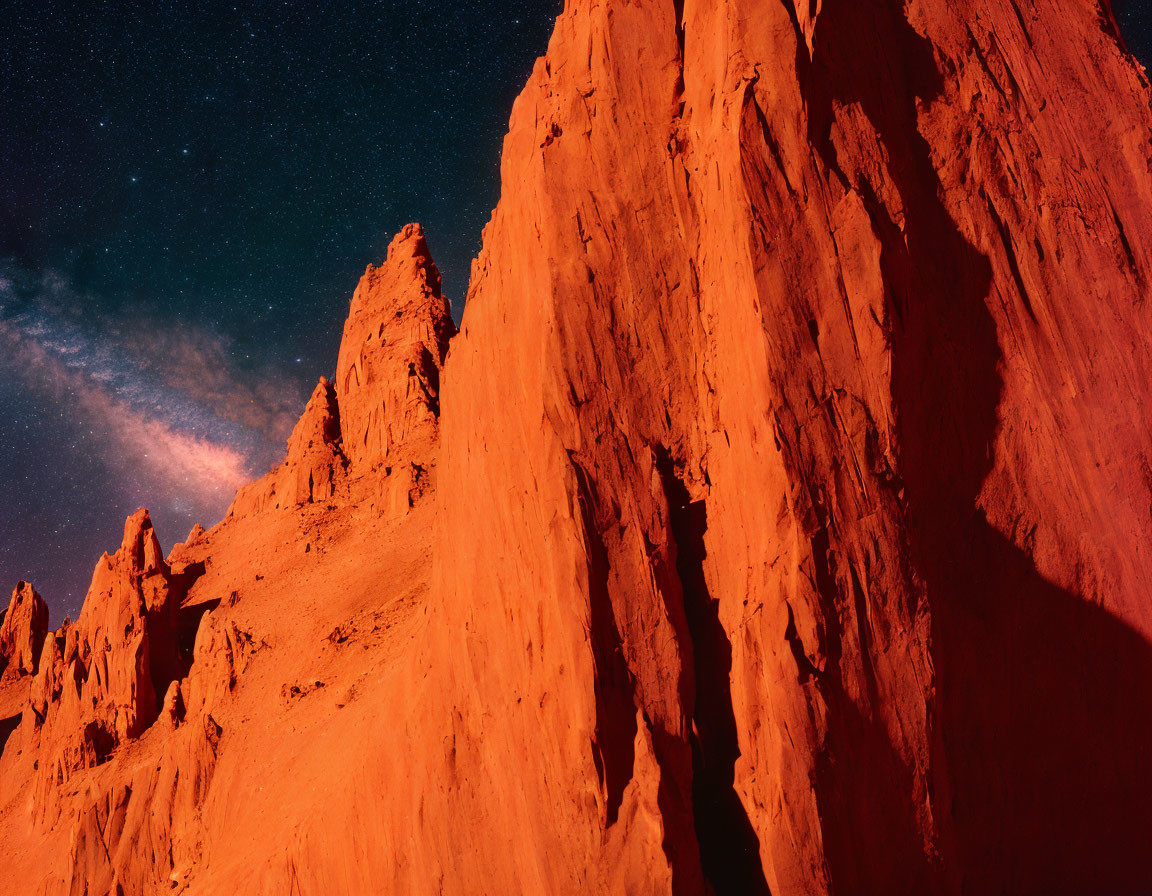 Starry night sky over red rock formations