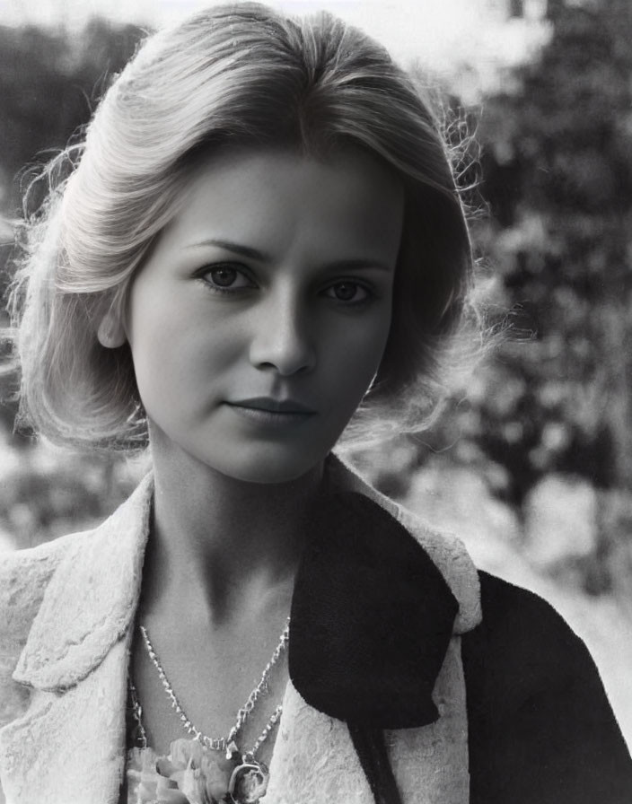 Monochrome image of woman with blonde hair in dark collar jacket