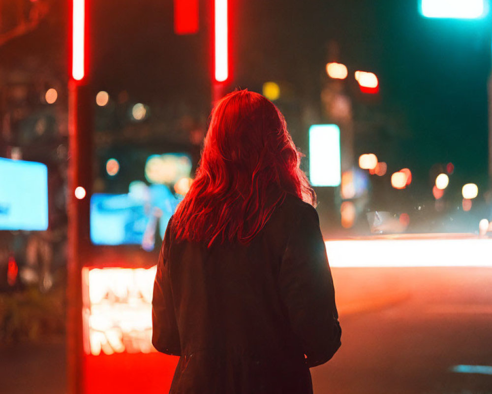 Person with Long Hair Standing at Night Under Neon Lights