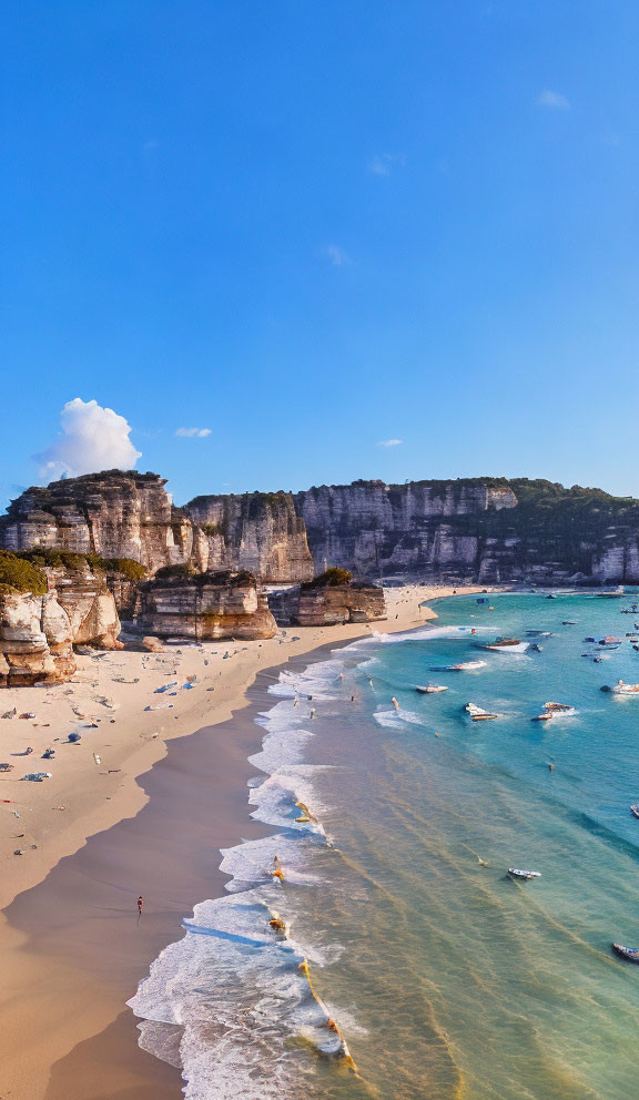 Cliffside beach scene with boats, sky, and lone figure