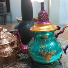 Elegant teapots with gold accents by city skyline window