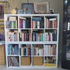 Inviting reading nook with bookshelf, books, warm lighting, and plants