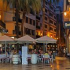 Warmly lit cafe and vintage lamps on elegant street corner at dusk