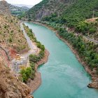 Turquoise River in Verdant Valley with Red-Rock Formations