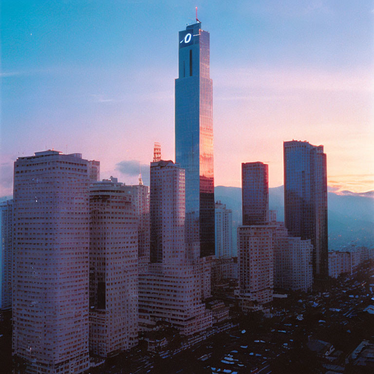 City skyline at sunset with tall building and skyscrapers.