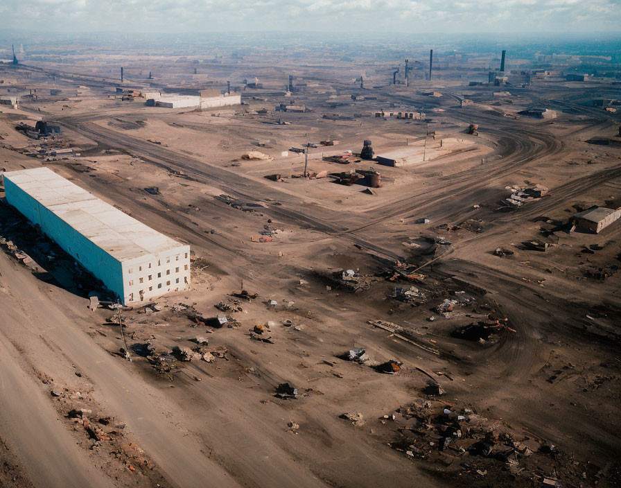 Expansive industrial site with large building and dirt roads