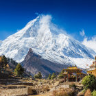 Snow-capped mountains, cottages, flowers under blue sky