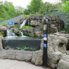 Scenic waterfall landscape with footbridge and lamp post