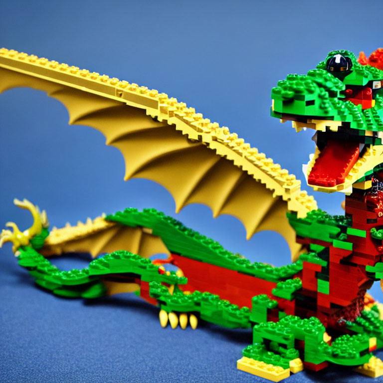 Colorful Lego Dragon with Green Body and Red Wings on Blue Background