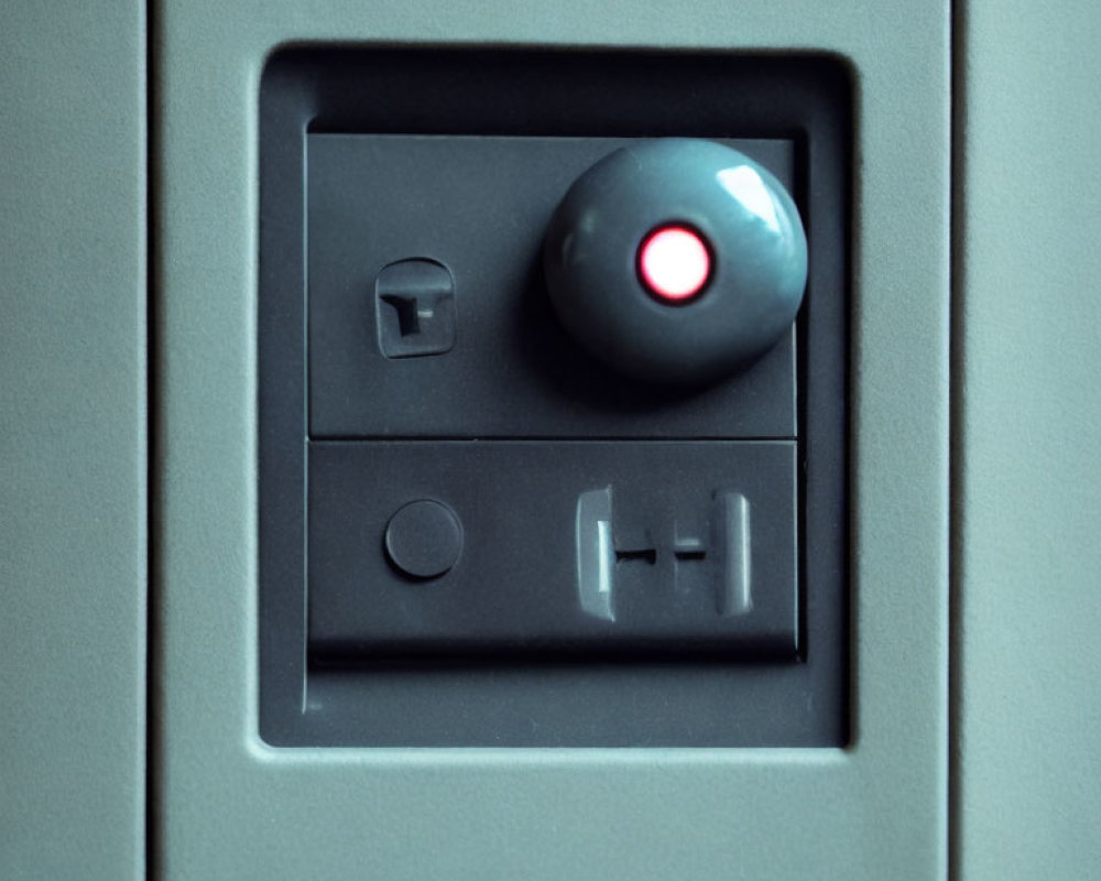 Grey panel with red light, toggle switch, push button, sliding cover slot.