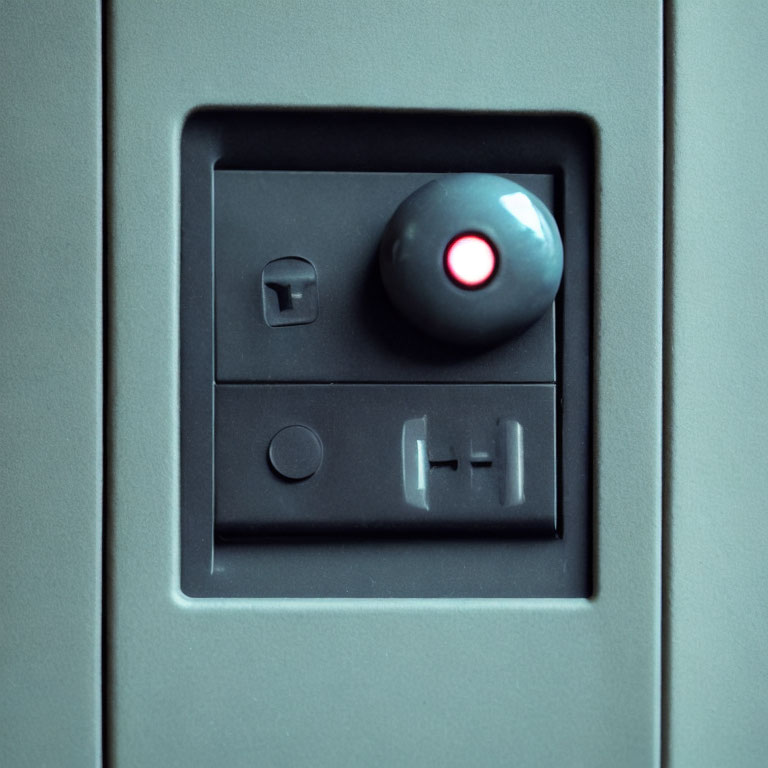 Grey panel with red light, toggle switch, push button, sliding cover slot.