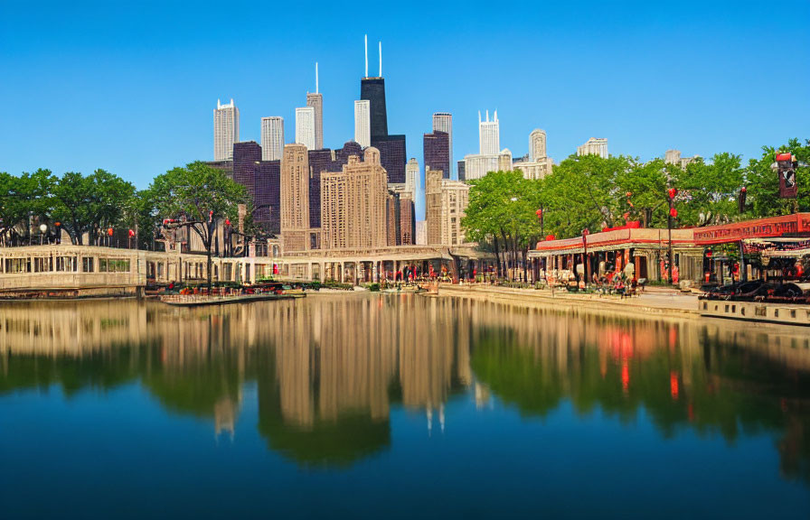 Urban skyline mirroring on calm water with lush trees and blue sky