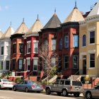 Victorian-style houses and futuristic cars in sunny day scene