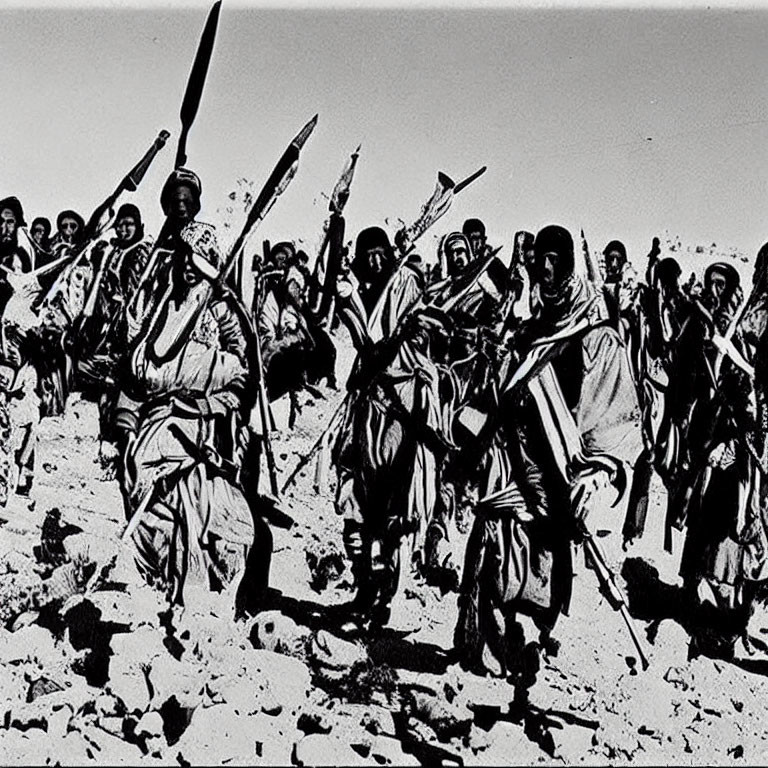 Traditional attired group marching with raised spears under clear sky