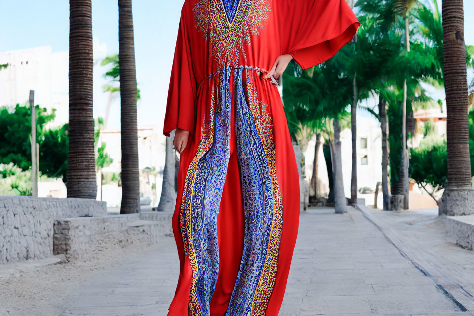 Vibrant Red Kaftan with Blue Patterns Near Palm Trees