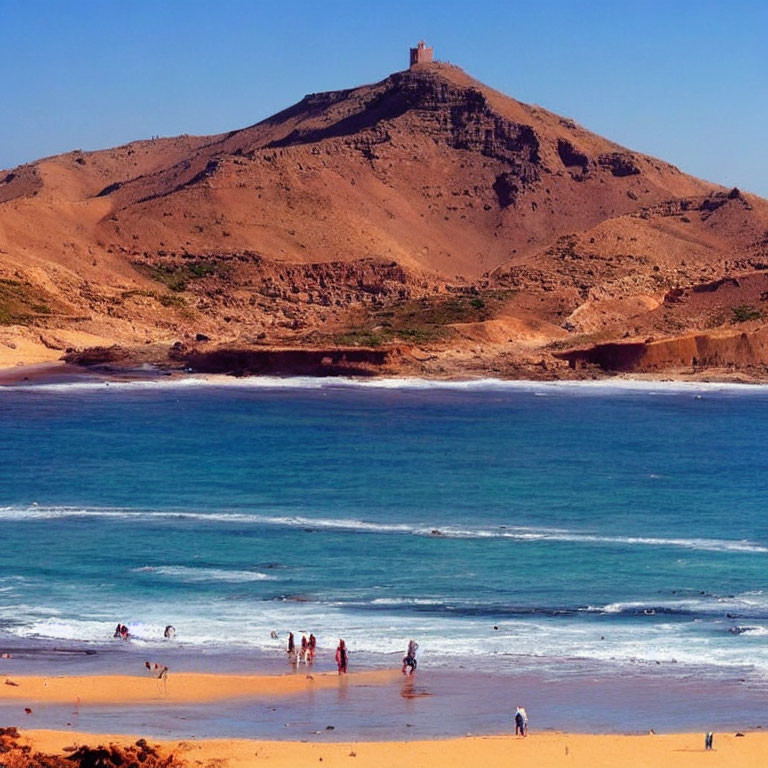 Hilltop structure overlooking beach with sunbathers