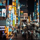 Colorful city street painting with billboards and traffic at night.