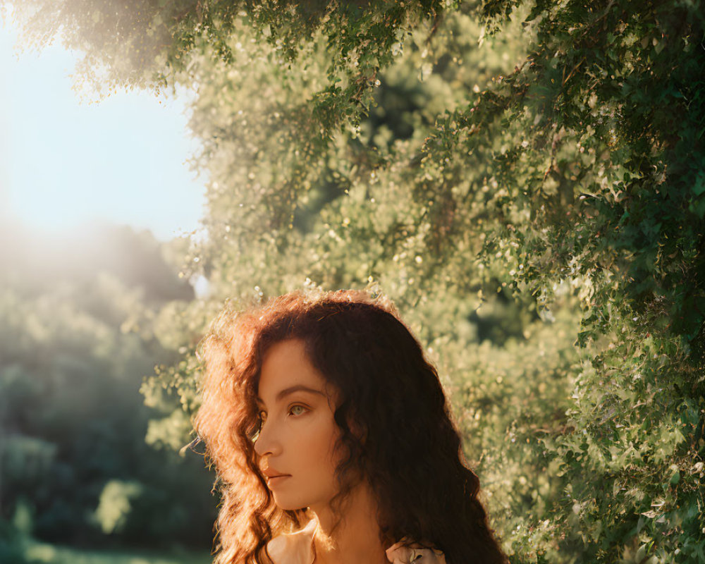 Curly-haired woman in green foliage under soft sunlight