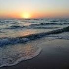 Tall ships with full sails on rolling ocean waves in golden light