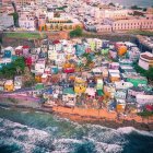 Colorful Village on Hillside with River, Boats, and Glowing Lights