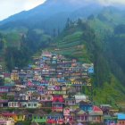 Colorful impressionistic painting of hilltop village with mountains in bold swirls