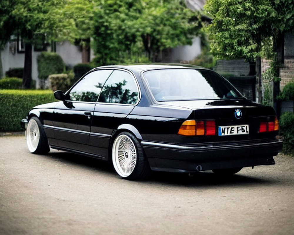 Black BMW E31 8 Series Coupe with Pop-Up Headlights and Aftermarket Wheels