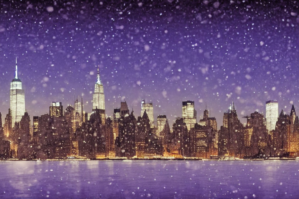 Snow-covered city skyline at night with illuminated buildings and falling snowflakes