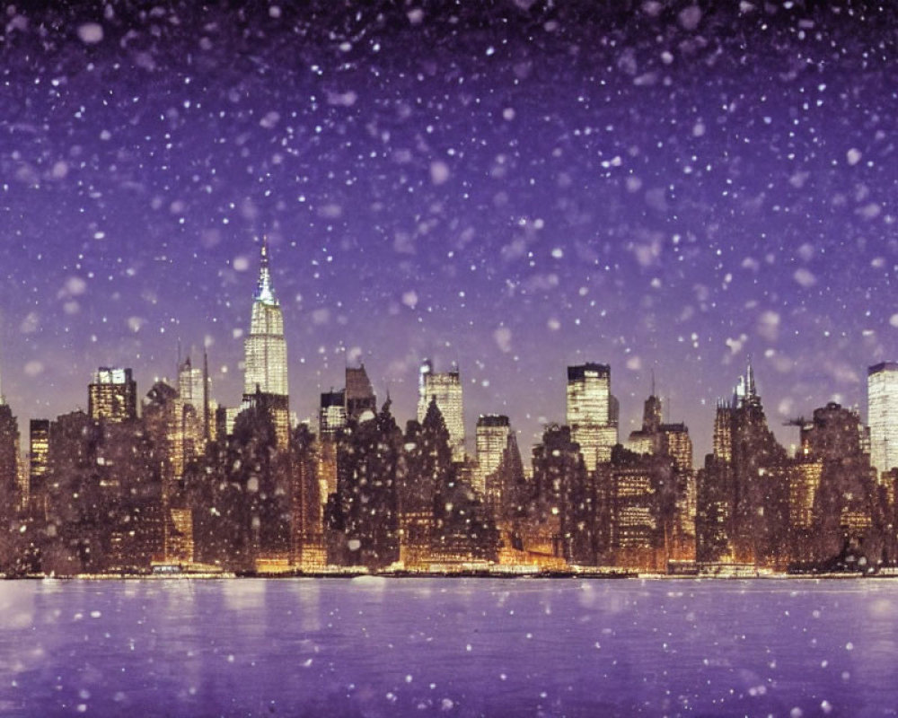 Snow-covered city skyline at night with illuminated buildings and falling snowflakes