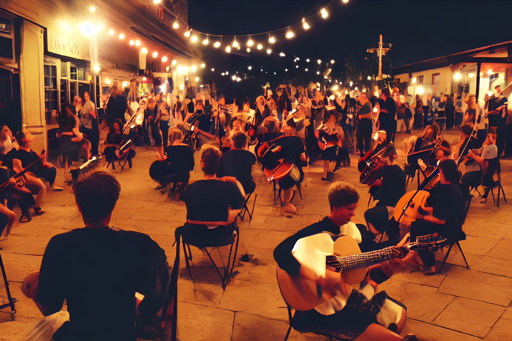 Group of musicians playing string instruments under string lights at night