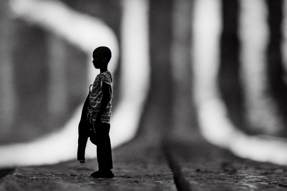 Monochrome miniature figure amidst blurred parallel lines symbolizing solitude