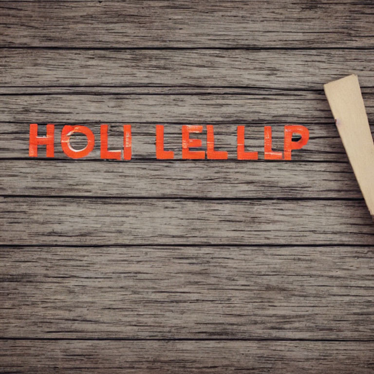 Orange "HOLI" word on wooden background with mirrored letters